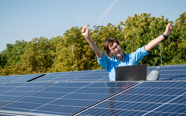 Frau jubelt auf Solardach