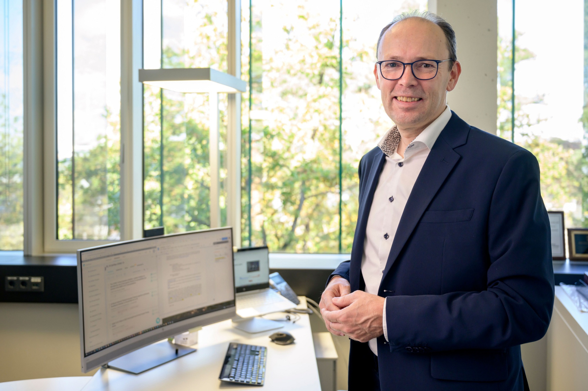 Mann steht in seinem Büro