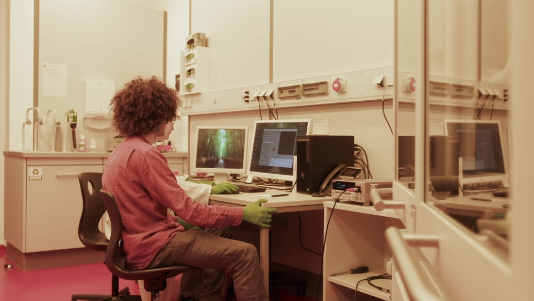 Man sitting in fromt of a computer in a lab.